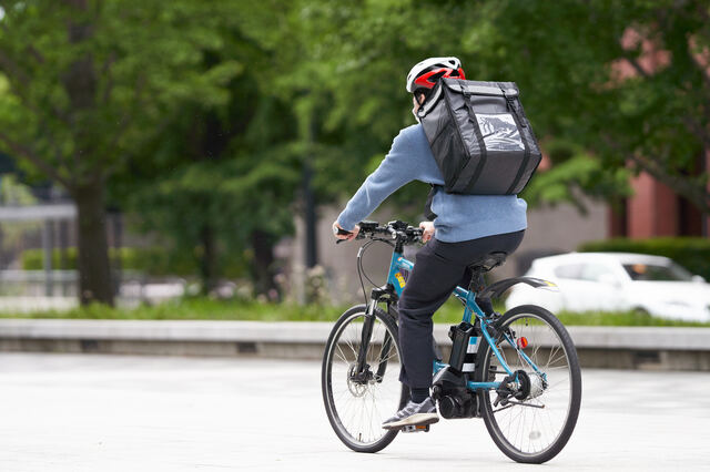 自転車で走行するデリバリー配達員